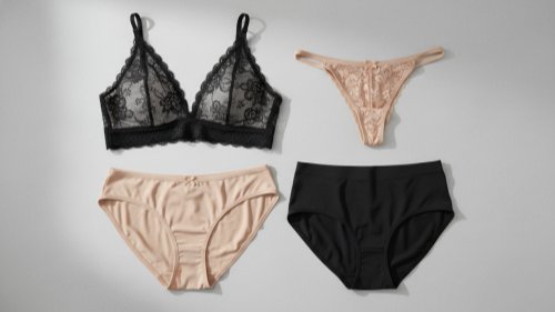 Folded bralette, bikini, thong, and seamless underwear on grey stone surface.